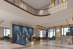 Eine geräumige Lobby mit gewölbter Decke, einer Sitzecke mit blauen Möbeln und einer Wand mit geometrischen Mustern.