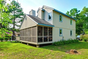 A two-story house with a large glass windowed room, a chimney, and a garage. - Amazing Location! Updated Bethany Beach Retreat! (Bethany Beach)