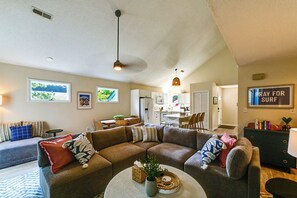 A living room with a sectional sofa, a dining area, and a kitchen in the background. - Amazing Location! Updated Bethany Beach Retreat! (Bethany Beach)