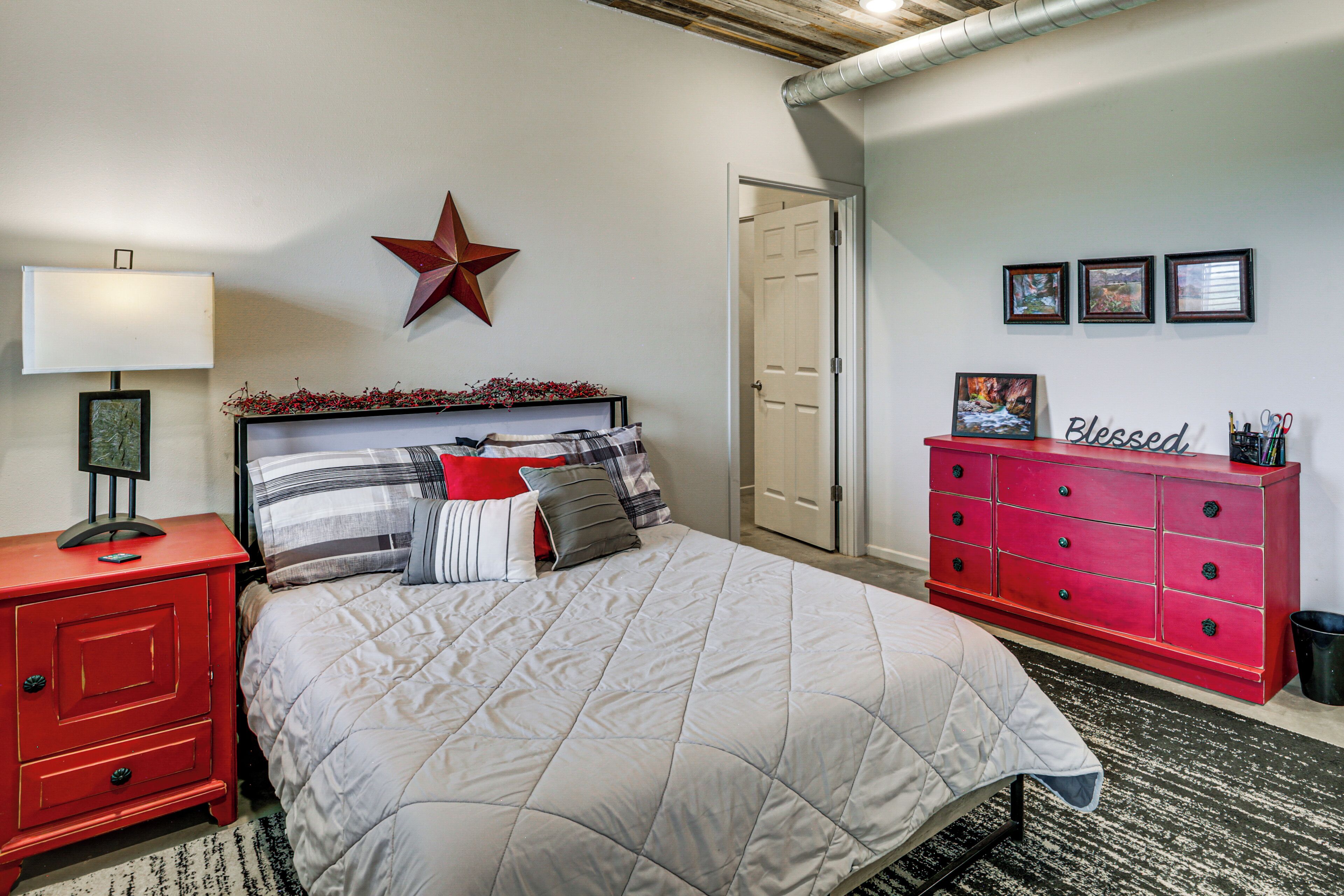 Ein Schlafzimmer mit einem Bett, einem Nachttisch, einer Kommode und einer Stern-Dekoration an der Wand.