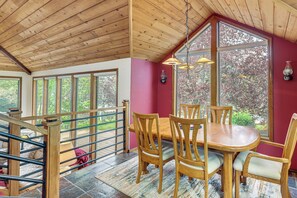 A dining area with a wooden table and chairs, large windows, and a wooden ceiling. - Fire Pit & Wildlife Views! Tranquil Bend Retreat (Bend)