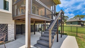A two-story house with a covered porch, a staircase, and a fenced yard. - Modern Lake House with Beautiful Shoreline (Frankston)