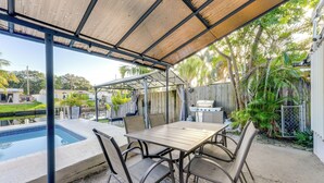 Eine Außenpatio mit Pool, Tisch und Stühlen.