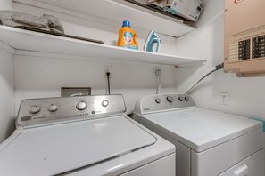 A laundry area with two white washing machines, a shelf with cleaning supplies, and an electrical panel. - 3 Mi to Hollywood Beach! Canal-Front Haven w/ Dock (Hollywood)
