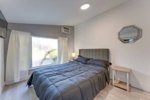 A bedroom with a bed, a bedside table, a mirror, and a window with curtains. - 3 Mi to Hollywood Beach! Canal-Front Haven w/ Dock (Hollywood)