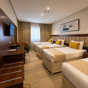 A hotel room with two beds, a desk, a chair, and a television. - Park Elite Hotel (Makkah)