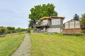 A two-story house with a balcony, a greenhouse, and a well-maintained lawn. - Hot Tub & Puget Sound View! Whidbey Island Retreat (Clinton)