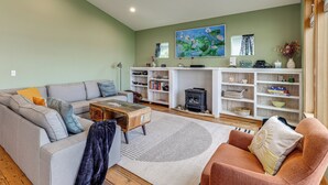 A living room with a sofa, armchair, coffee table, and fireplace.