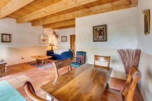 Un coin repas comprenant une table en bois, des chaises, un canapé et une lampe.