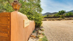 A rustic wooden fence with a metal lantern and a sign that reads 'Casa Bella.' - Traditional Taos Adobe Casita: Comfortable & Quiet (Taos)