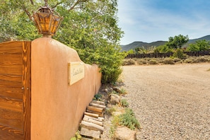 A rustic wooden fence with a metal lantern and a sign that reads 'Casa Bella.' - Traditional Taos Adobe Casita: Comfortable & Quiet (Taos)