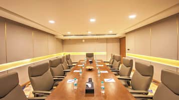 A conference room with a long table, chairs, water bottles, and a projector.