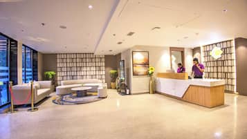 A modern reception area with a reception desk, seating area, and a large window offering a view.