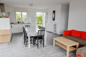 A modern living space with a dining area, kitchen, and seating area. - LA MAISON DES DUNES, sleeps 7, near the sea (Les Moitiers-d'Allonne)