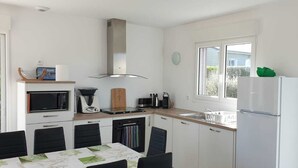 A compact kitchen with a microwave, toaster, kettle, and a refrigerator. - LA MAISON DES DUNES, sleeps 7, near the sea (Les Moitiers-d'Allonne)