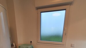A laundry area with a washing machine, a drying rack, and a window with a view of the sky. - LA MAISON DES DUNES, sleeps 7, near the sea (Les Moitiers-d'Allonne)