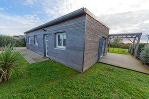 A modern house with a wooden exterior, a front door, and a small porch. - LA MAISON DES DUNES, sleeps 7, near the sea (Les Moitiers-d'Allonne)