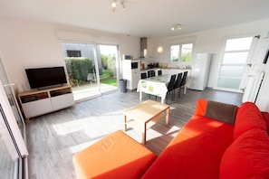 A modern living room with a sofa, a coffee table, and a television. - LA MAISON DES DUNES, sleeps 7, near the sea (Les Moitiers-d'Allonne)