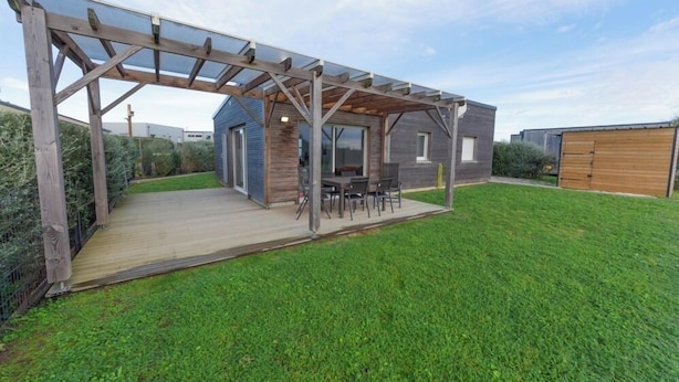 A modern house with a wooden deck, a covered patio, and a small shed. - LA MAISON DES DUNES, sleeps 7, near the sea (Les Moitiers-d'Allonne)