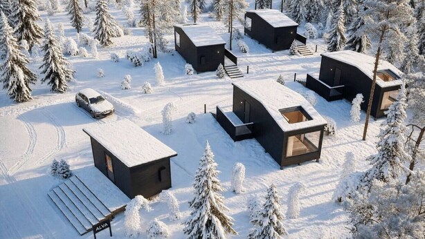 Een besneeuwd landschap met meerdere moderne vakantiehuisjes, elk met een unieke architectuur, grote ramen en een plat dak.