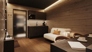 Ein modernes Zimmer mit Holzboden, einer Couch, einem Esstisch und einer Küchenzeile.