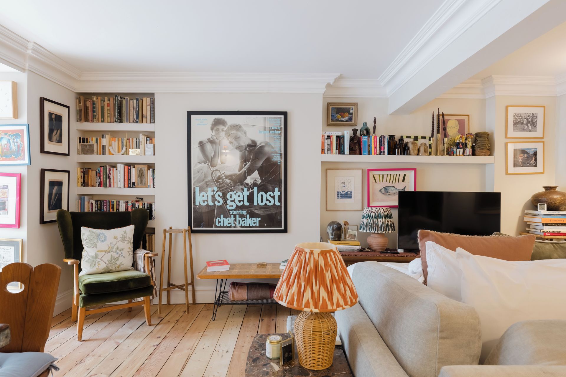 A cozy living room with a sofa, a chair, a coffee table, and a bookshelf filled with books.