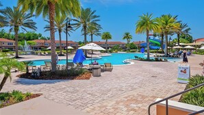 A resort pool area with palm trees, lounge chairs, and a blue umbrella. - Remodeled home, Regal Oaks-September Special Price (Kissimmee)