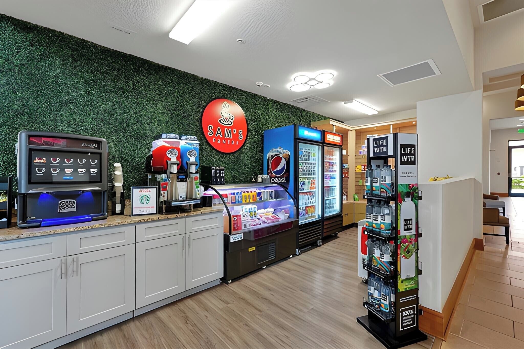 Ein Bereich mit Selbstbedienungstheke, einer Kaffeemaschine, einem Pepsi-Kühlschrank und einem Warenautomaten.