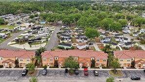 A residential area with single-family homes, a parking lot, and a row of mobile homes. - Remodeled home, Regal Oaks-September Special Price (Kissimmee)