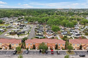 A residential area with single-family homes, a parking lot, and a row of mobile homes. - Remodeled home, Regal Oaks-September Special Price (Kissimmee)