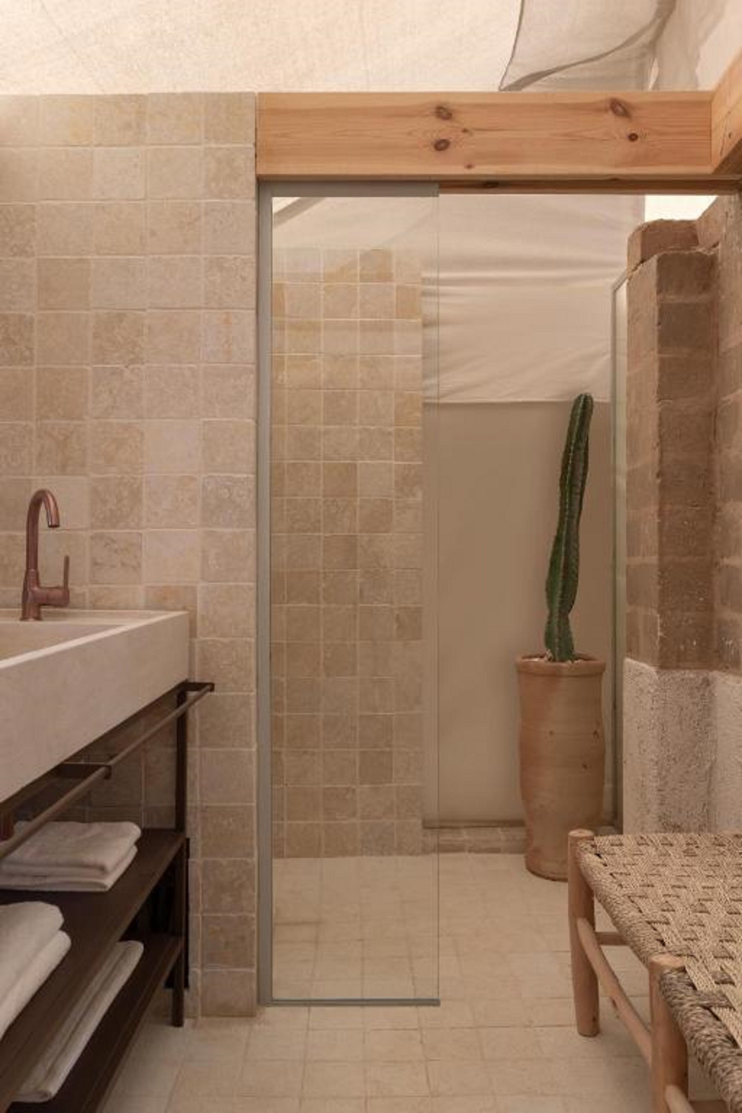 Un baño con ducha, lavamanos y estante con toallas.
