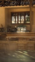 Una cocina con cafetera, licuadora y ventana con vistas a edificios.