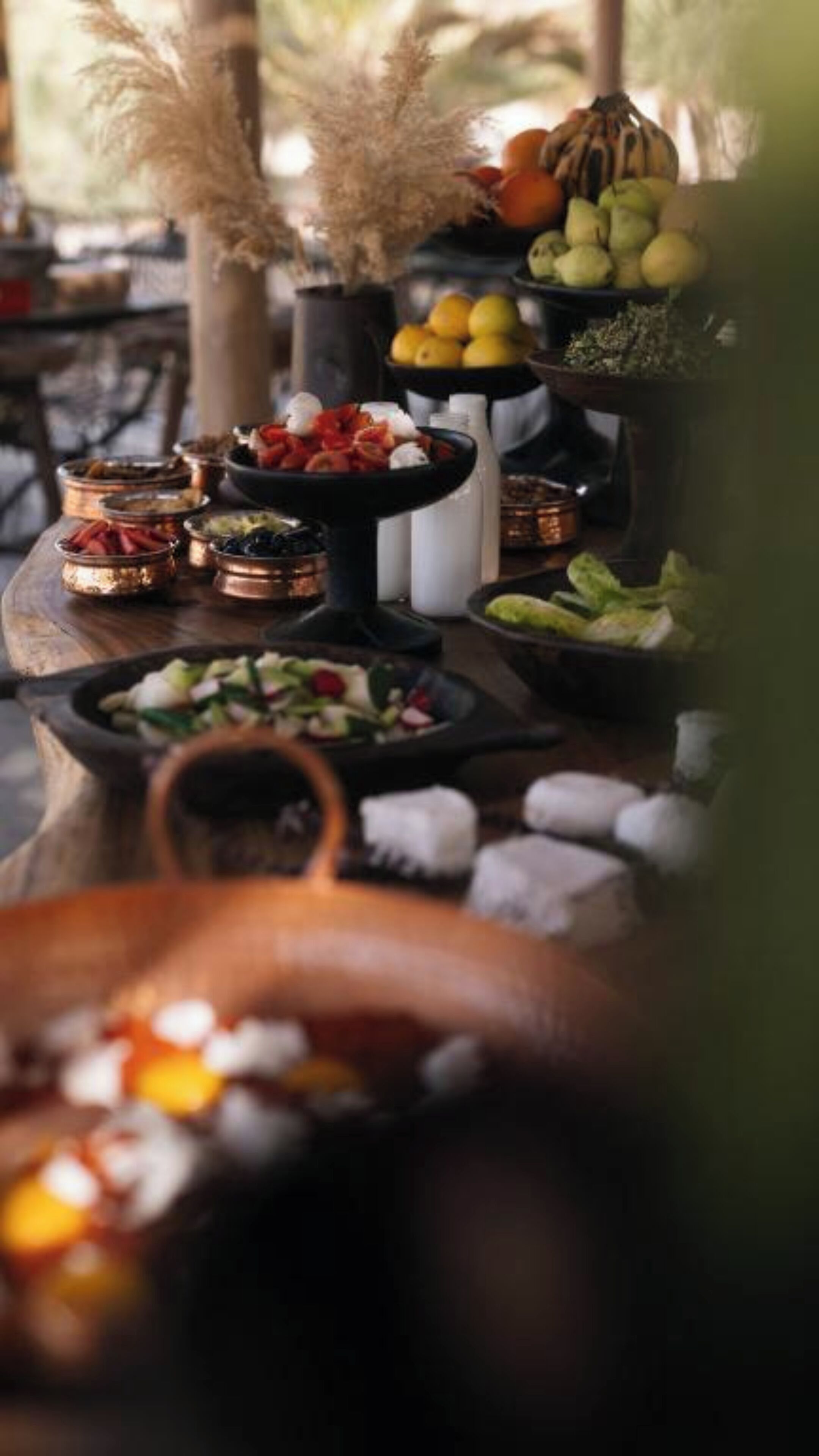 A table with various food items and a rustic setting.