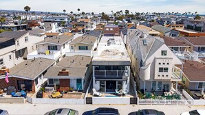 Un barrio residencial con casas, un estacionamiento y vista al océano.