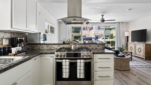 Una cocina moderna con horno empotrado, cocina a gas y un amplio ventanal.