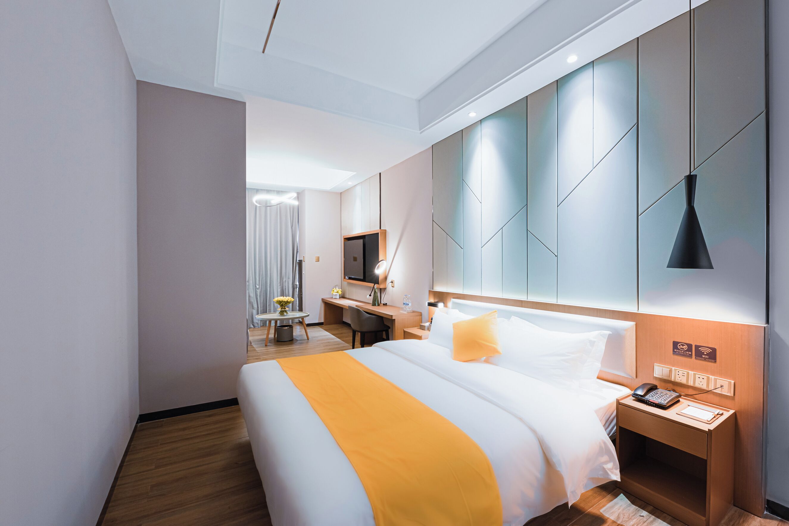 Una habitación de hotel con cama, mesita de noche y escritorio con silla.