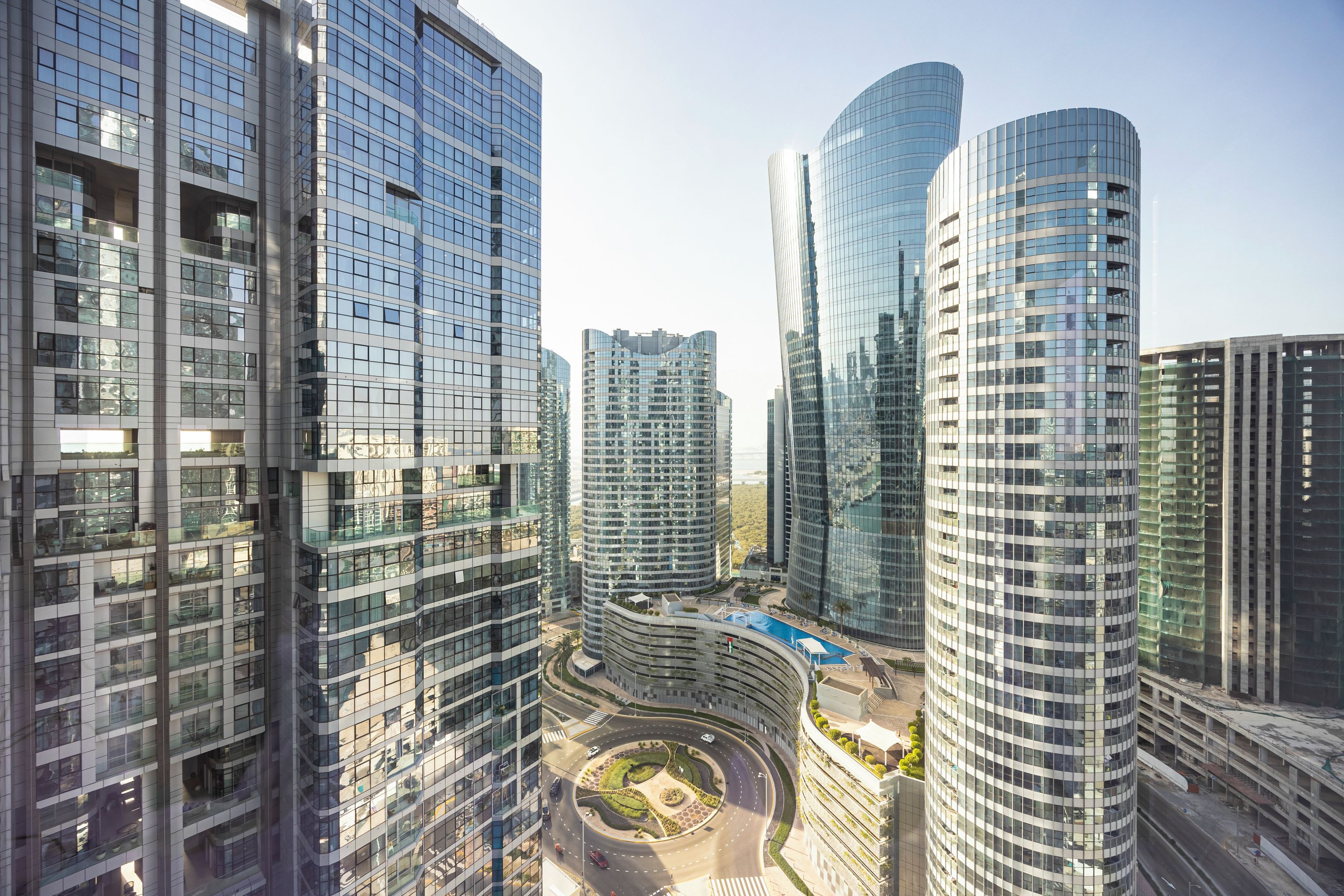 A high-rise urban area with modern architecture, including a circular road and a pool area.