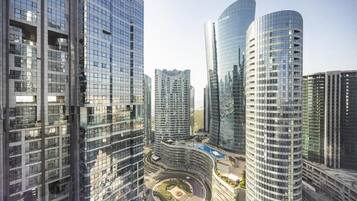 A high-rise urban area with modern glass buildings, a central roundabout, and a clear sky.