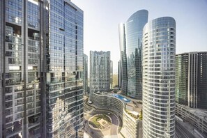 A high-rise urban area with modern glass buildings, a central roundabout, and a clear sky.