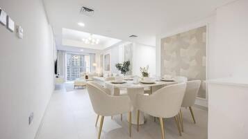 A modern dining area with a round table, white chairs, and a neutral color scheme.