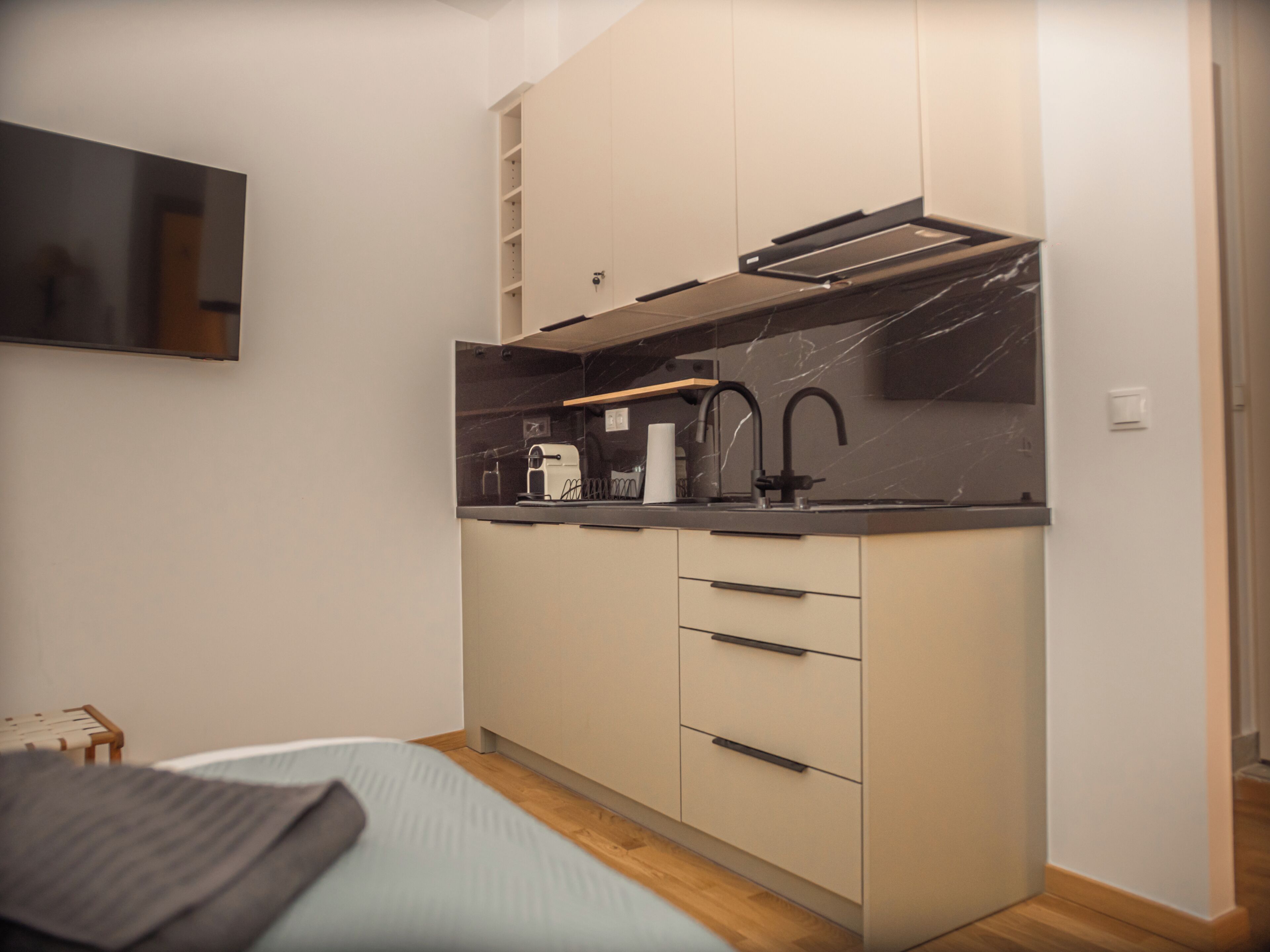 Una kitchenette compacta con horno integrado, lavamanos y encimera.