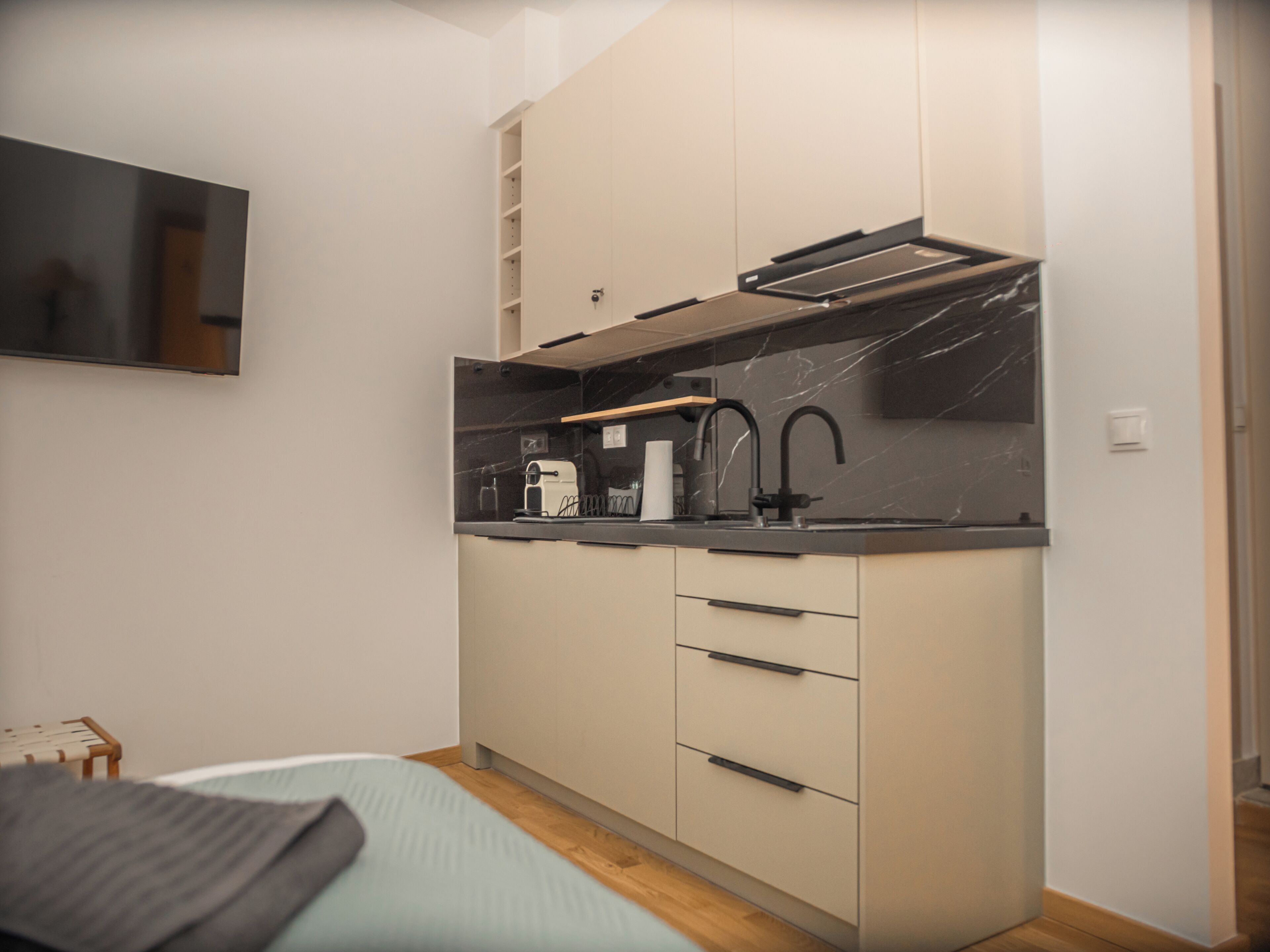 A compact kitchen with a built-in oven, a sink, and a microwave.