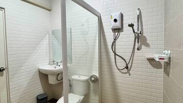 A bathroom with a glass-enclosed shower, a toilet, a sink, and a mirror.