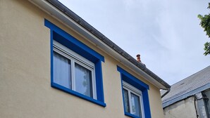 Un edificio a due piani con facciata beige e infissi blu.