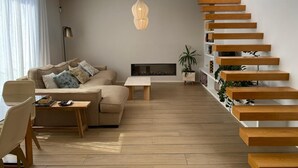Ein modernes Wohnzimmer mit einer Couch, einem Couchtisch und einem Kamin.