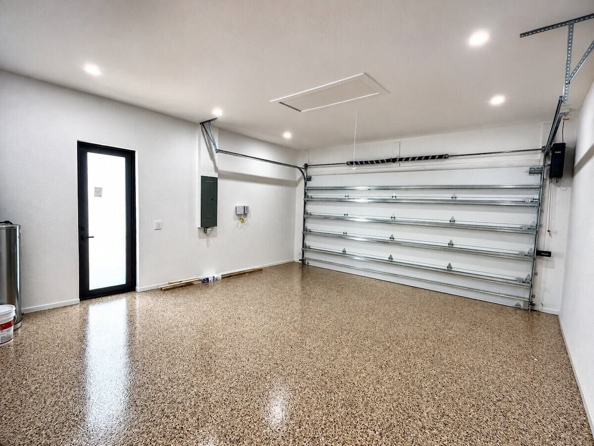 Een ruime kamer met een gepolijste vloer, een deur en een metalen schapwand.