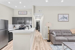 Una cocina moderna con armarios oscuros, una isla central y un microondas.
