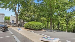 A parking area with a car, a small kiosk, and a hedge. - Timber and Trail  2BR/2BA Family Friendly (Kimberling City)
