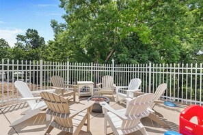 A patio area with Adirondack chairs, a fire pit, and a white fence. - Timber and Trail  2BR/2BA Family Friendly (Kimberling City)