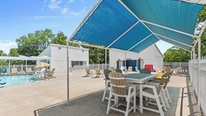 An outdoor patio with a pool, covered seating area, and a table with chairs. - Timber and Trail  2BR/2BA Family Friendly (Kimberling City)